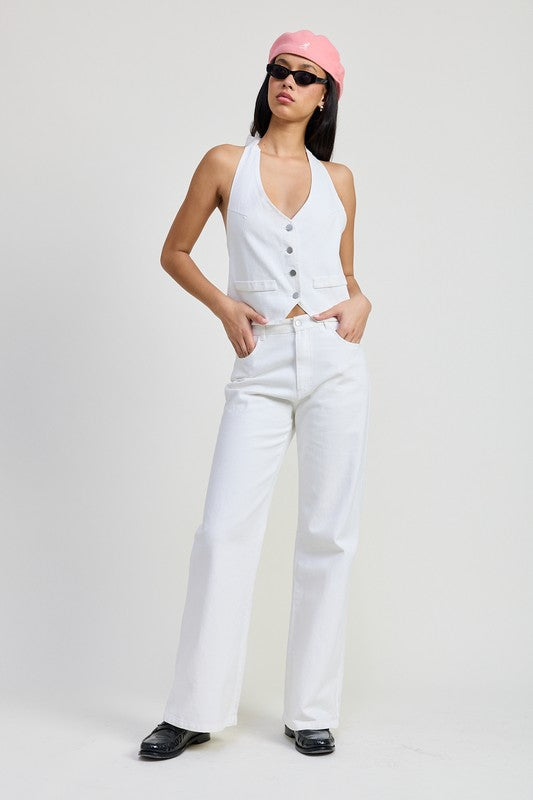 Model wearing Emory Park folded fitted denim pants in white paired with white vest and pink cap