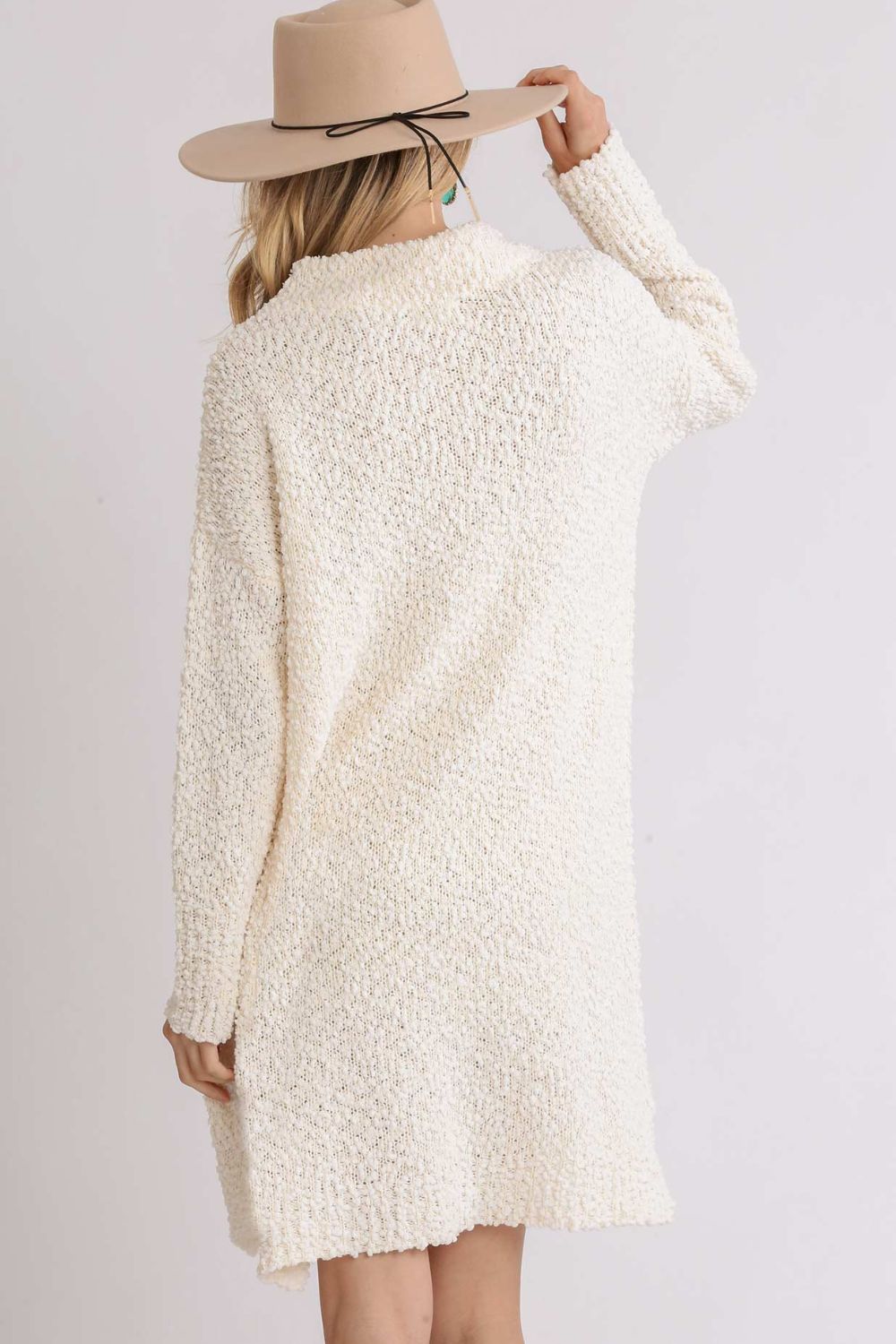 Back view of a cozy cream high-low boucle sweater dress perfect for casual wear and layering
