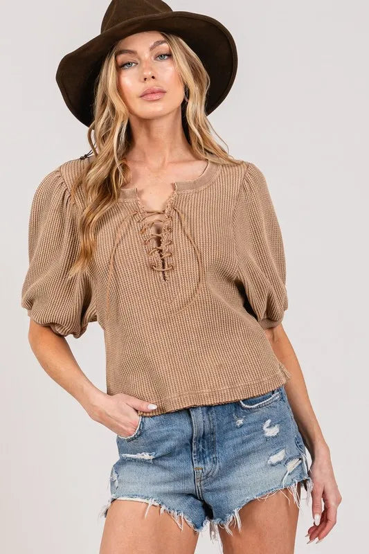 Lace-Up Waffle Knit Top in beige with puff sleeves, styled with denim shorts and a wide-brim hat