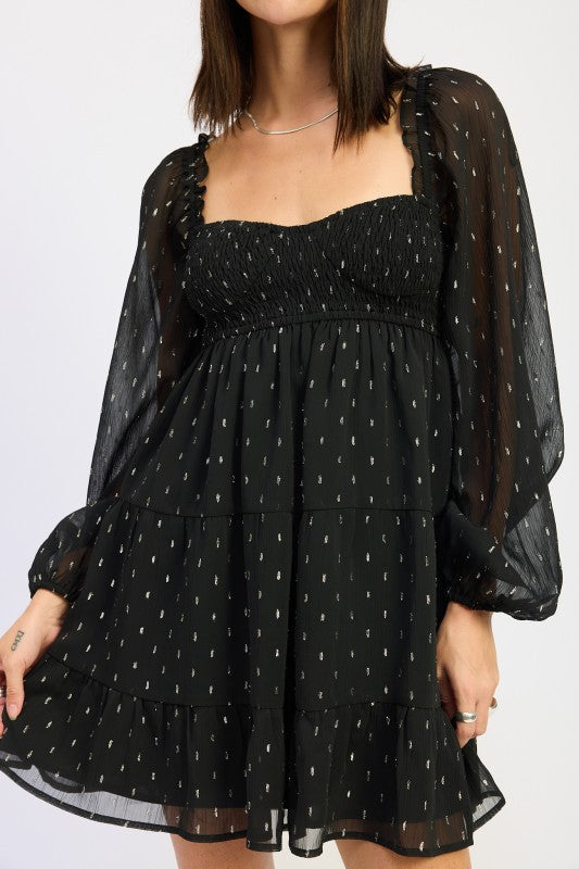 Emory Park Long Sleeve Smocked Baby Doll Mini Dress in black with sheer puff sleeves and a ruffled hem.