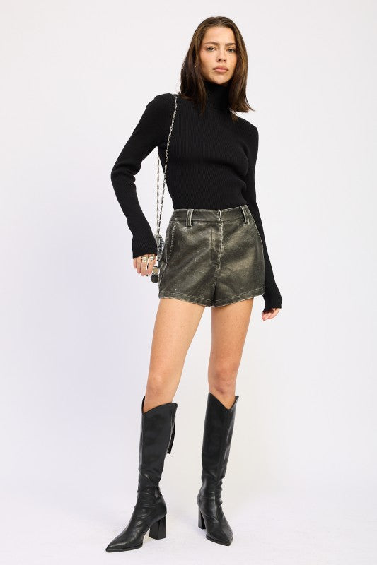 Model wearing a black Long Sleeve Turtle Neck Bodysuit with stylish shorts and knee-high boots by Emory Park