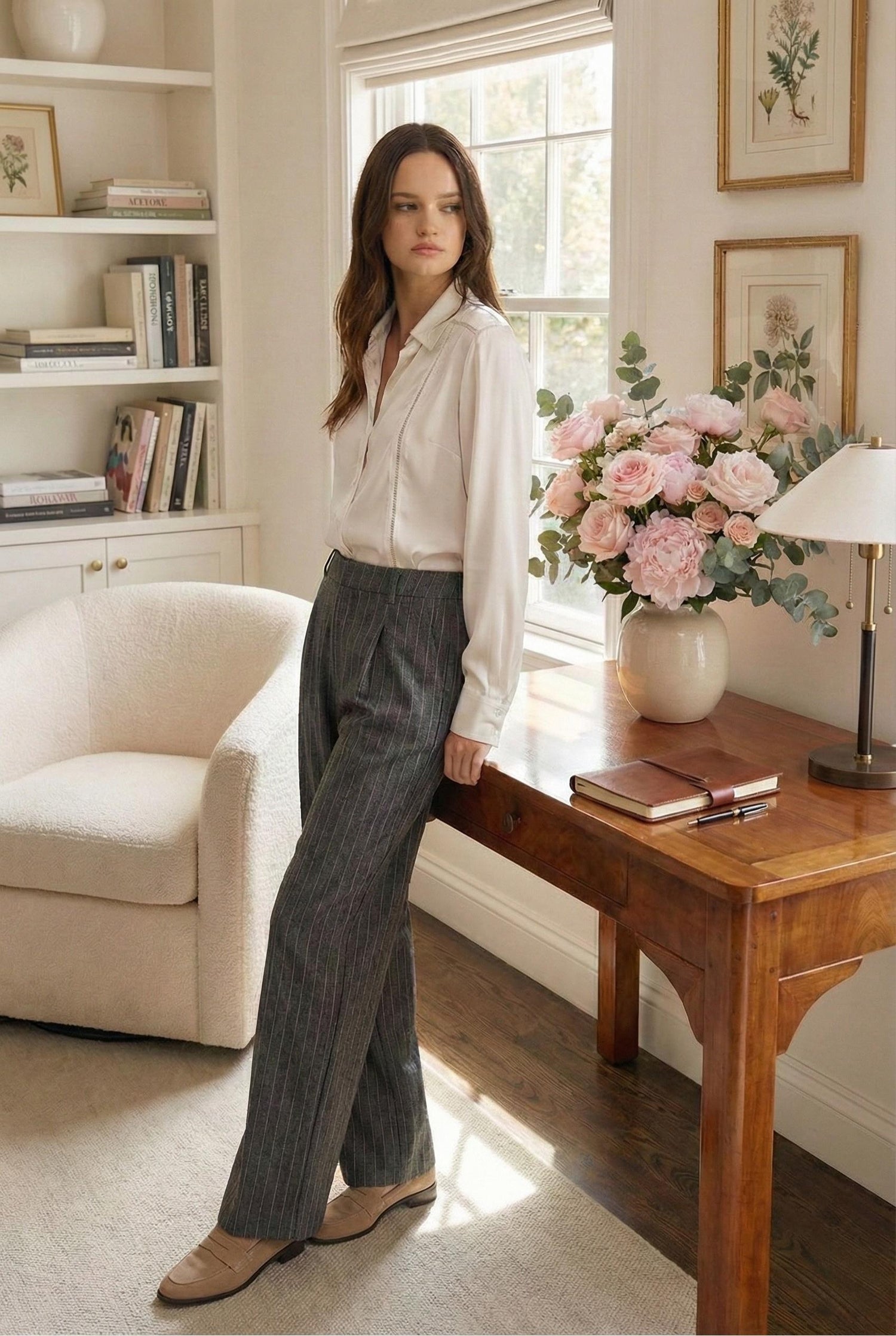 Model wearing Emory Park Loose Fit Pinstripe Pants in gray standing in luxury home office