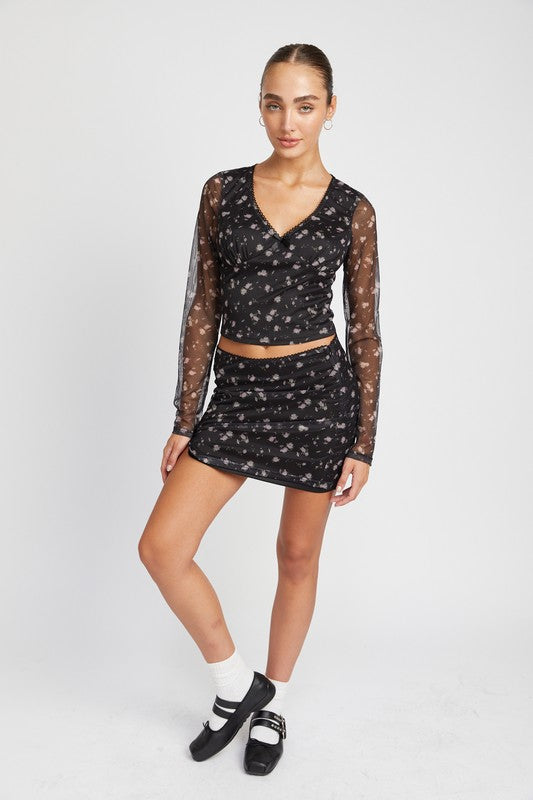 Emory Park black Mesh Mini Skirt With Satin Bow Detail worn with matching floral mesh top