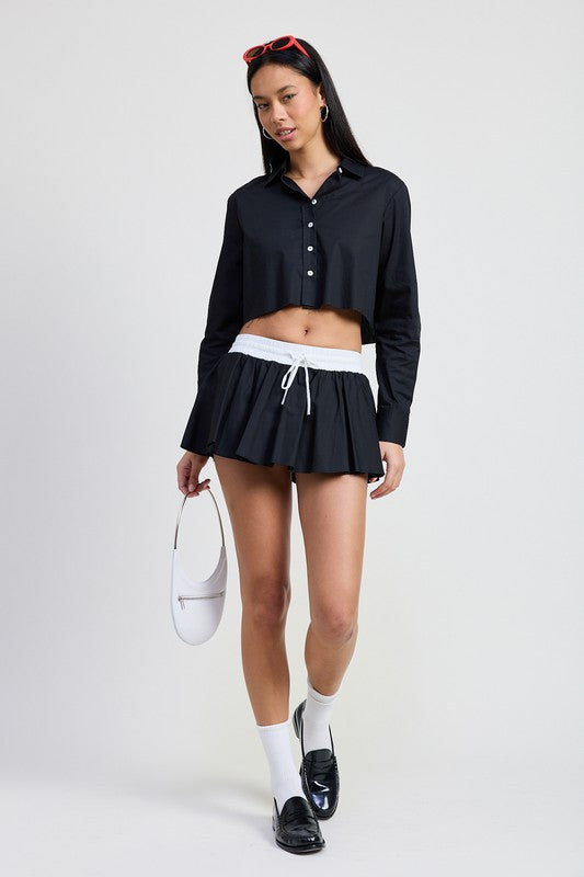 Emory Park Mini Contrast Waistband Skirt in black with white waistband worn with black cropped shirt and white socks