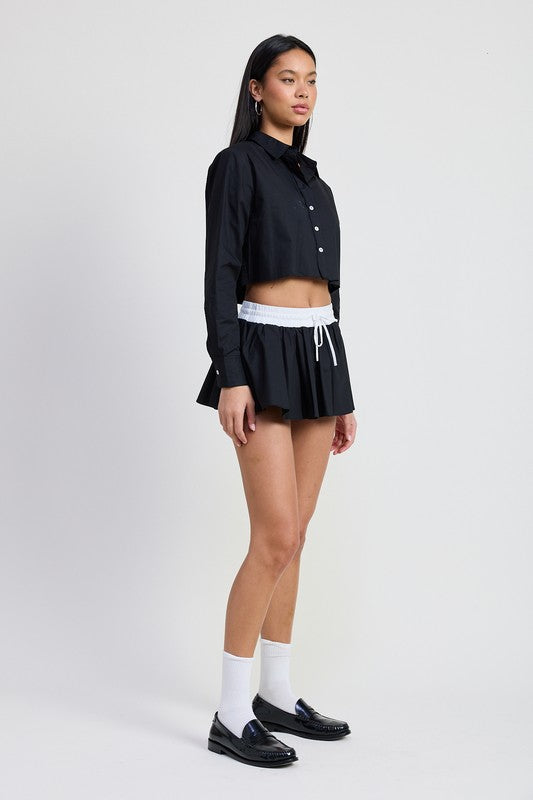 Emory Park Mini Contrast Waistband Skirt in black with white waistband worn with a cropped black button shirt