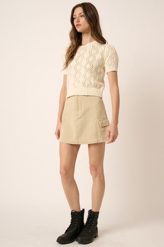 Woman wearing Mittoshop Cargo Mini Skirt with Side Pockets paired with a chunky knit sweater and black boots