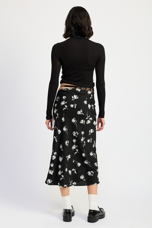 Back view of woman wearing Emory Park Mixe Media Asymmetrical Maxi Satin Skirt with floral print and black top