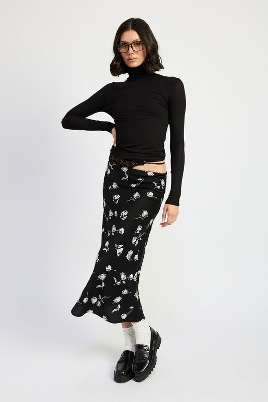 Emory Park Mixed Media Asymmetrical Maxi Satin Skirt in black with white floral print styled with black turtleneck pose