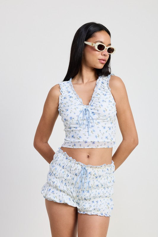 Emory Park Ruched Floral Top With Bow Detail in white with blue flowers worn by a woman with sunglasses