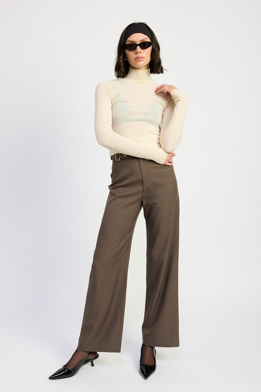 Model wearing Emory Park brown wide leg Trouser Pants With Adjustable Waist Buckle paired with cream ribbed turtleneck and black heels