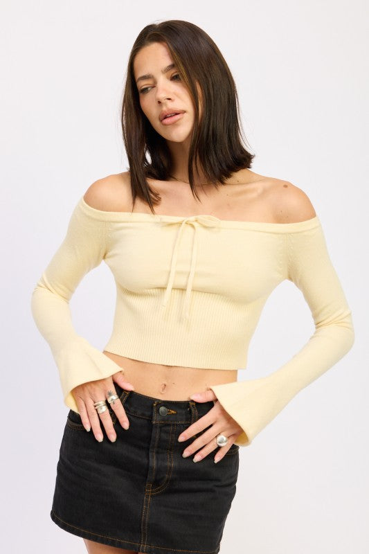 Emory Park Off-Shoulder Cropped Top in pale yellow ribbed knit with tie front and bell sleeves worn with black denim skirt