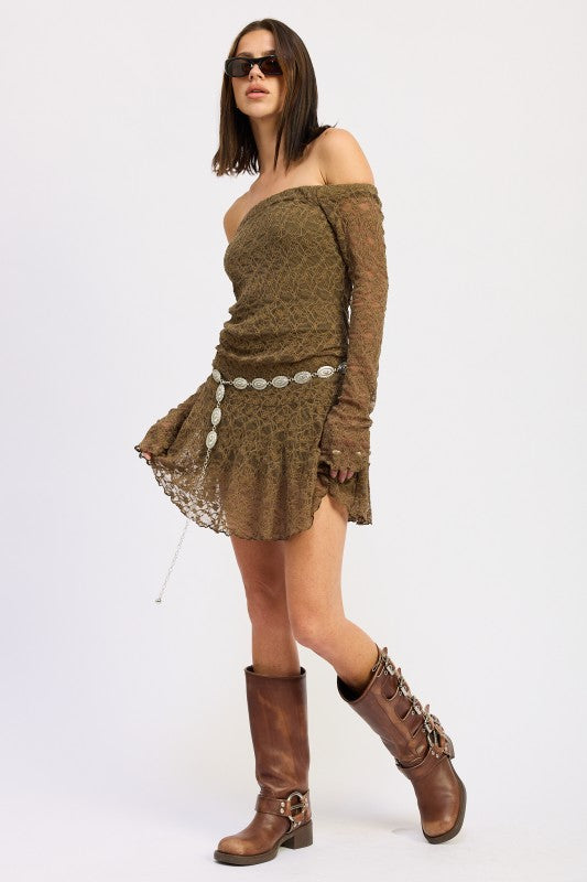 Woman wearing an Off Shoulder Lace Mini Dress in olive green with stylish long sleeves and chic boots