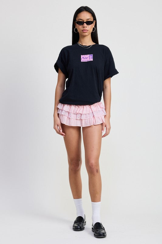 Woman wearing Emory Park Gingham Mini Ruffle Skort in pink with layered ruffles and black casual t-shirt