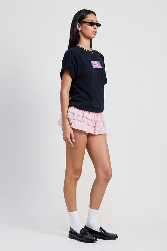 Woman wearing Emory Park Gingham Mini Ruffle Skort in pink with layered ruffles styled with black t-shirt and sunglasses