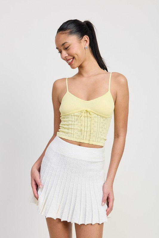 Emory Park white Pleated Mini Skirt worn by smiling woman paired with yellow crop top