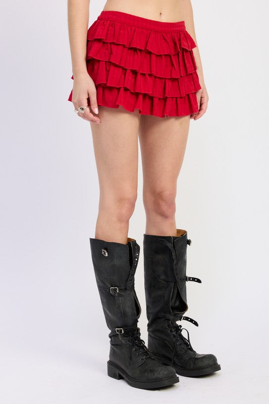 Emory Park red tiered ruffle mini skirt paired with black knee-high lace-up boots