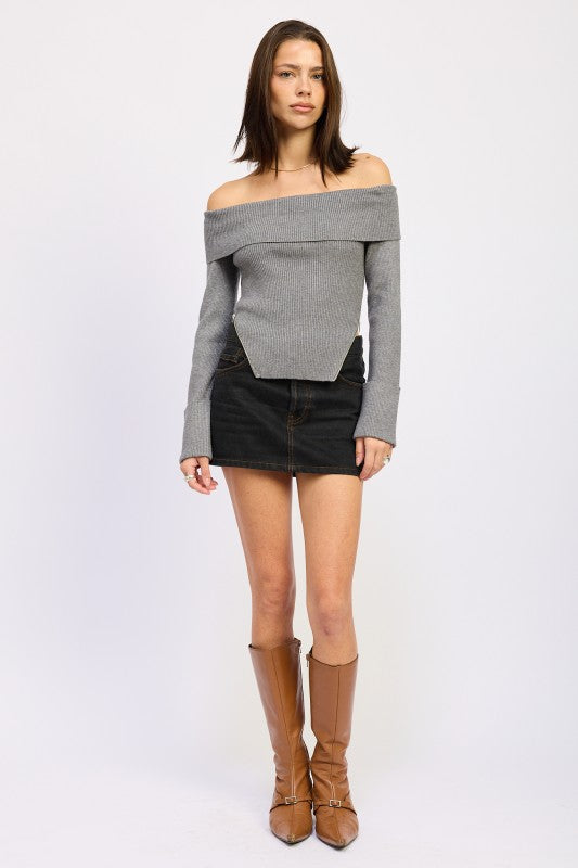 Model wearing Emory Park Ribbed Off-Shoulder Sweater With Zipper in gray paired with denim mini skirt and tan boots