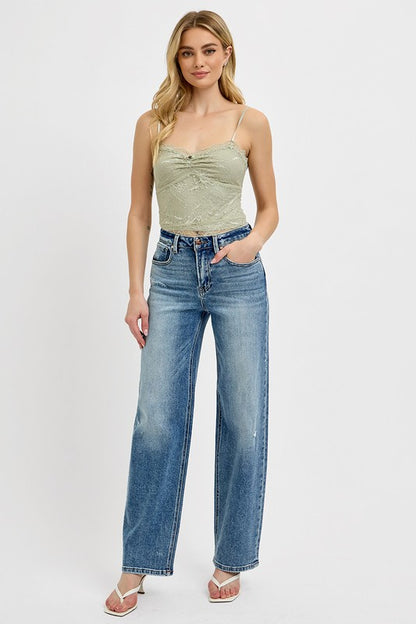 Model wearing RISEN Distressed Wide Leg Jeans with a green top and sandals, showcasing casual style.