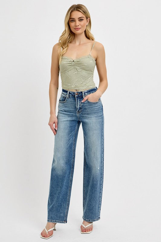 Model wearing RISEN Distressed Wide Leg Jeans with a green top and sandals, showcasing casual style.