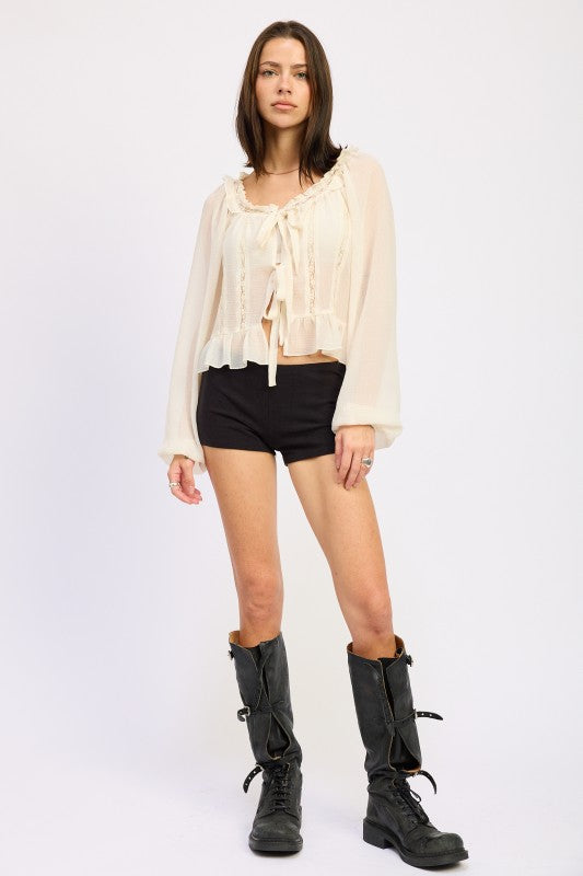 Emory Park Round Neck Long Sleeve Flared Blouse in cream, styled with black shorts and knee-high boots