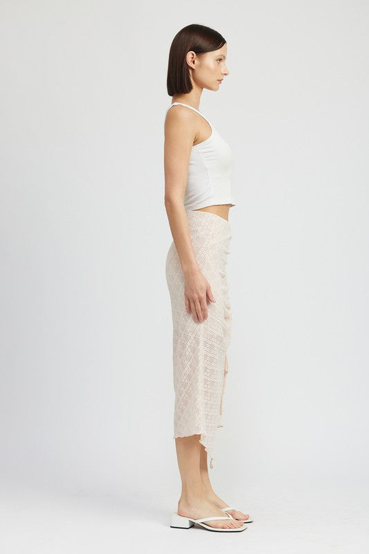 Side view of woman wearing Emory Park ruched lace skirt with high slit and white sleeveless top