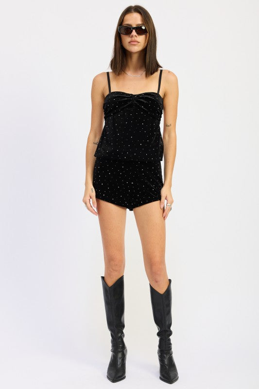 Stylish model wearing a Ruched Velvet Top With Rhinestones paired with matching shorts and knee-high black boots