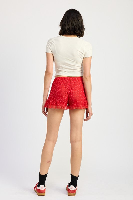 Emory Park red Ruffle Jersey Shorts worn by model with white top and platform sandals