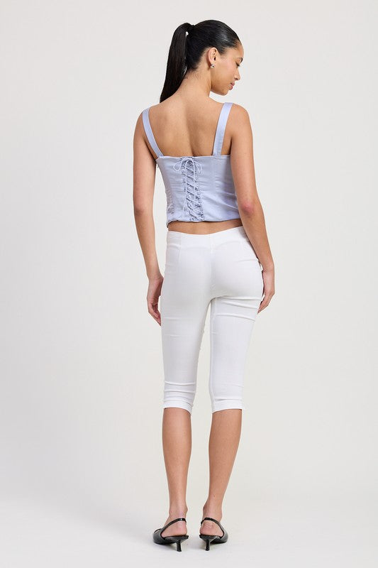 Woman wearing Emory Park satin bustier top with lace detail in light purple styled with white cropped pants