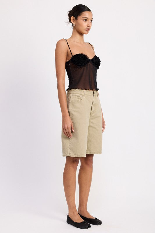 Model wearing Emory Park Sheer Mesh Floral Cup Cami Top in black with thin straps paired with beige knee length shorts