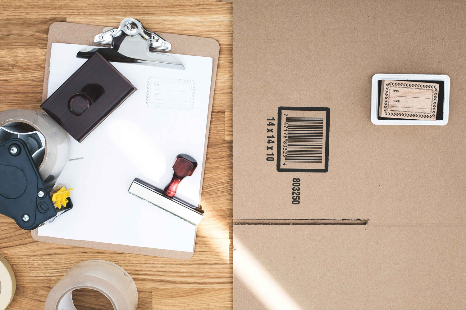 Cardboard box with a barcode label on a wooden surface with office supplies.