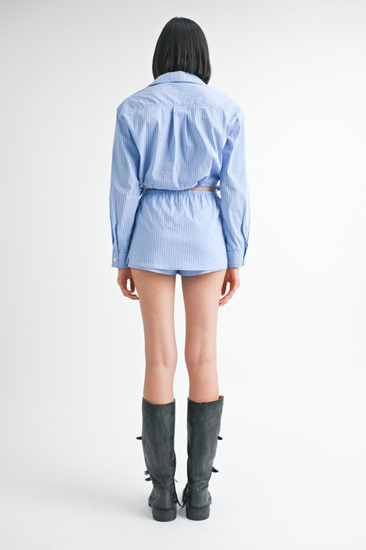 Emory Park model back view wearing Drawstring Mini Skort With Buttons in blue stripe shirt style with knee boots