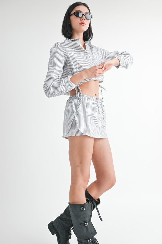 Model wearing Emory Park striped crop top and Drawstring Mini Skort With Buttons styled with sunglasses and black buckled boots