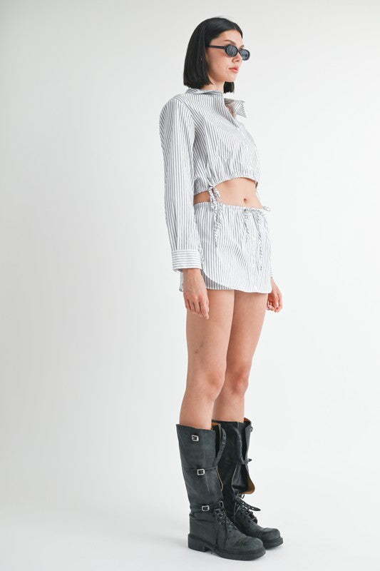 Model wearing Emory Park striped Drawstring Mini Skort With Buttons and matching cropped top with tall black boots