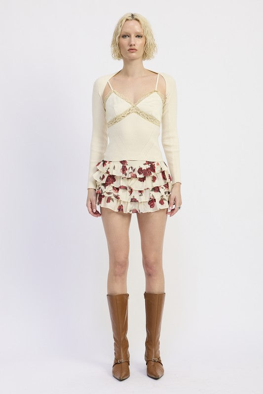 Emory Park model wearing Floral Mini Ruffle Skort cream and burgundy floral tiers with knee high brown boots