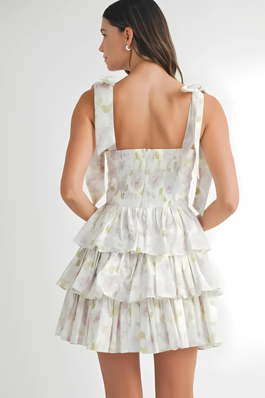 Back view of a floral shoulder tie mini dress with tiered layers and adjustable straps