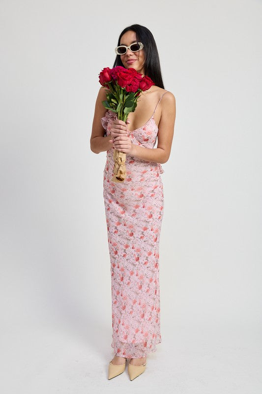 Woman wearing Emory Park pink floral spaghetti strap maxi dress holding bouquet of red roses