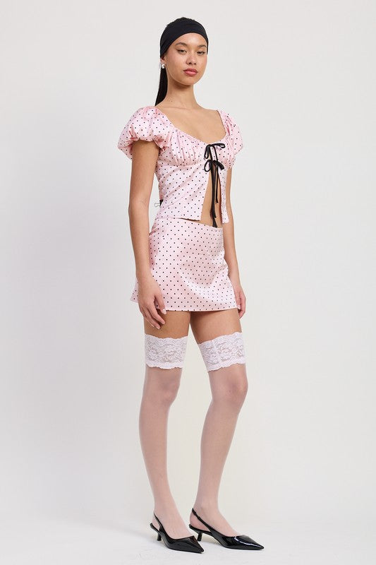 Woman wearing Emory Park Squared Neck Polka Dot Bubble Sleeve Top with matching skirt and lace thigh-high stockings