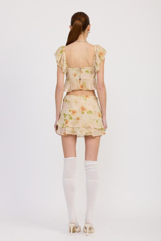 Back view of model wearing Emory Park squared neck top with cap sleeves and floral print skirt