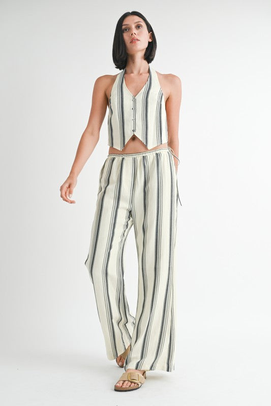 Emory Park striped straight leg pants in white with black vertical stripes worn with matching sleeveless vest
