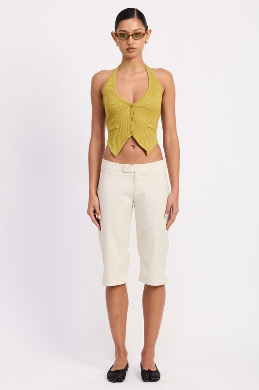 Model wearing Emory Park Tailored Mid-Rise Bermuda Pants in cream with knee length tailored fit paired with halter top