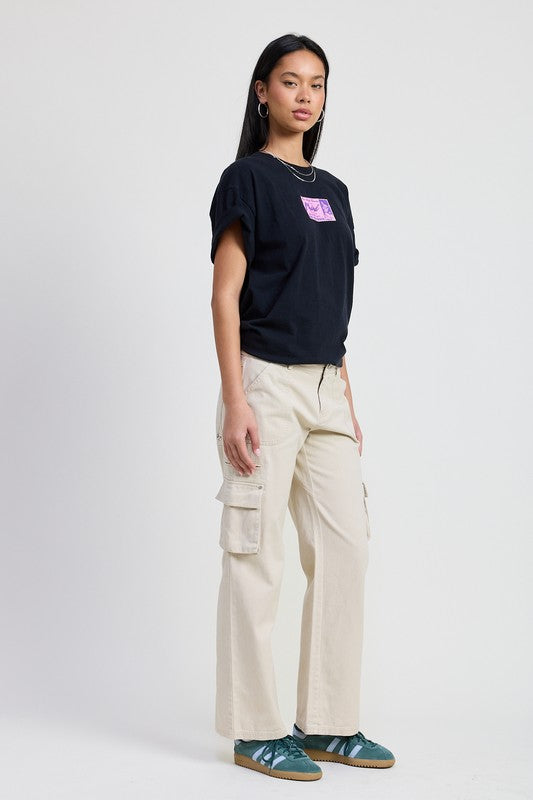 Model wearing Emory Park Pocket Cargo Pants in beige wide leg with side flap pockets styled with black tee