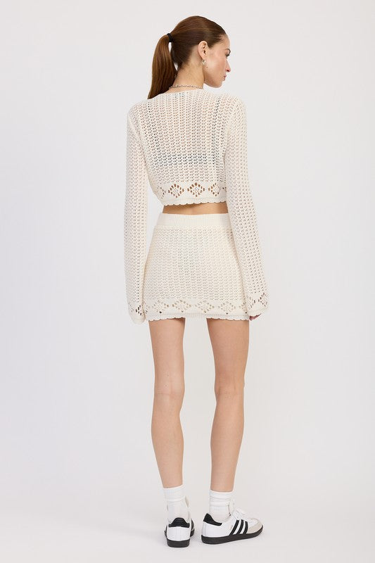 Model wearing Emory Park Lettuce Hem Mini Crochet Skirt in cream with matching long sleeve top